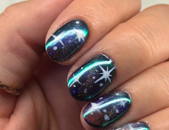 Nail art galaxia negra con brillos plateados